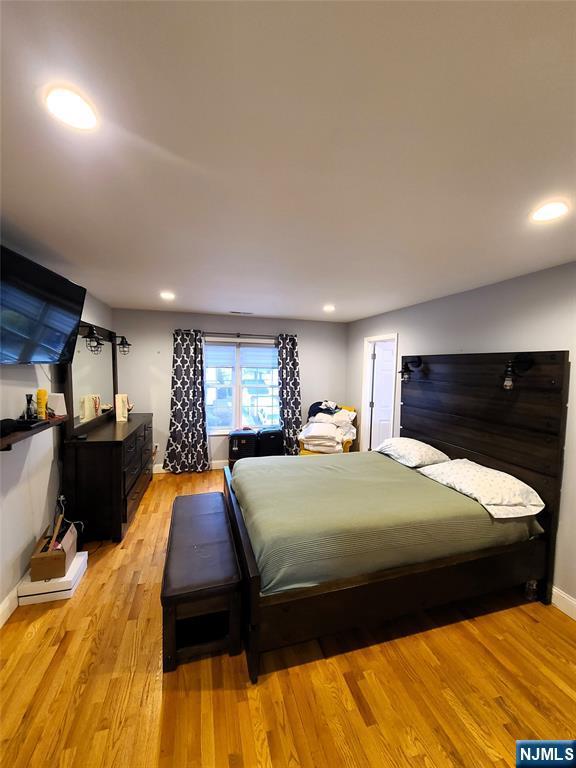 bedroom with baseboards, recessed lighting, and light wood-style floors