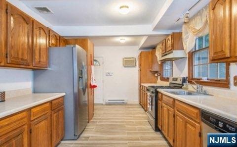 kitchen featuring visible vents, appliances with stainless steel finishes, light countertops, and a sink