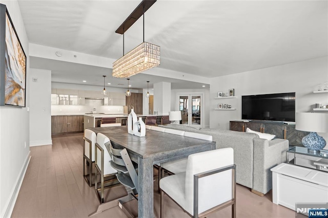 dining space with light wood-style flooring, baseboards, and recessed lighting