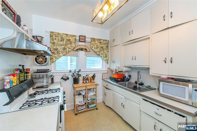 kitchen with white appliances, white cabinetry, light countertops, and a sink