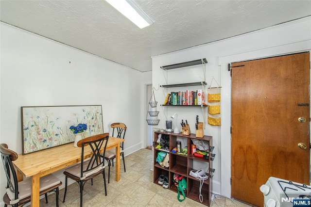 dining area featuring a textured ceiling and baseboards