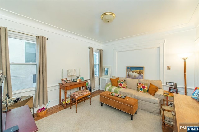 living area featuring a decorative wall and wood finished floors