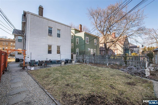 rear view of property with a patio area, a fenced backyard, and a lawn