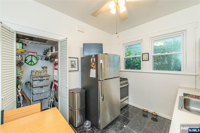 kitchen with appliances with stainless steel finishes, lofted ceiling, ceiling fan, and baseboards