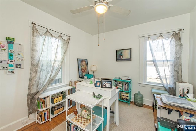 recreation room with ceiling fan, wood finished floors, and baseboards