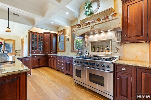 kitchen featuring beam ceiling, light wood-style floors, range with two ovens, tasteful backsplash, and coffered ceiling