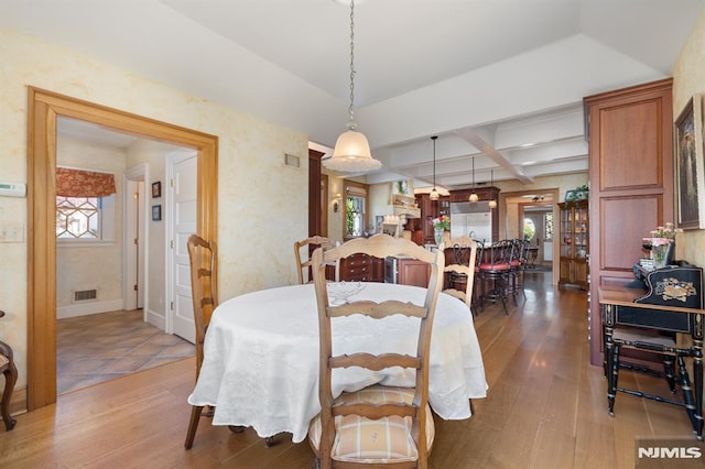 dining room featuring visible vents, plenty of natural light, hardwood / wood-style flooring, and coffered ceiling
