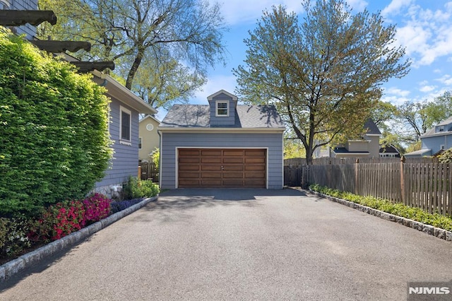 detached garage featuring fence
