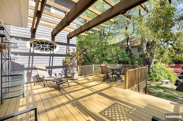 wooden deck featuring a pergola and outdoor dining area