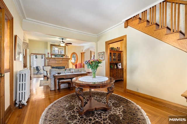 dining room with wood-type flooring, ornamental molding, ceiling fan, and radiator heating unit