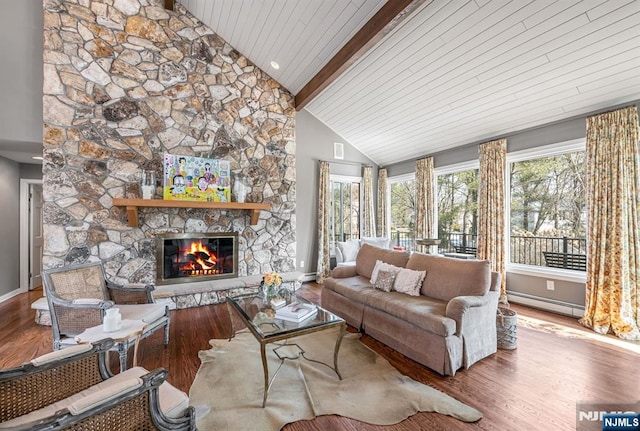 living area with beam ceiling, a fireplace, baseboard heating, wood finished floors, and high vaulted ceiling