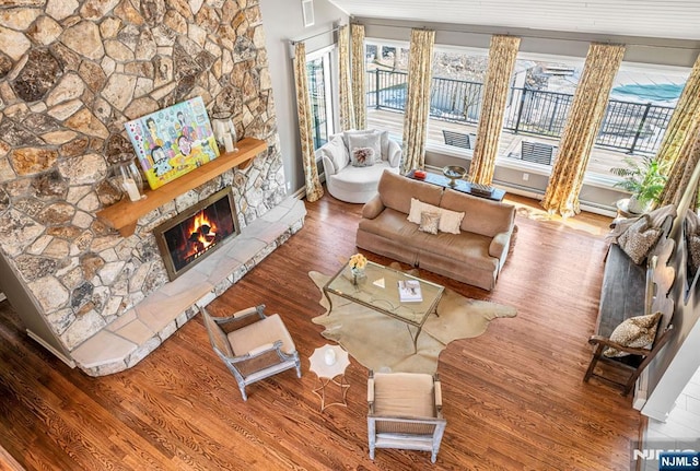 living area featuring a fireplace, visible vents, and wood finished floors