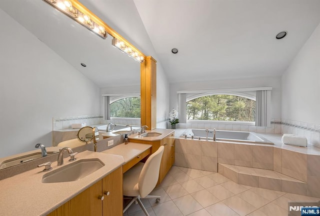 full bath with lofted ceiling, vanity, a bath, and tile patterned floors