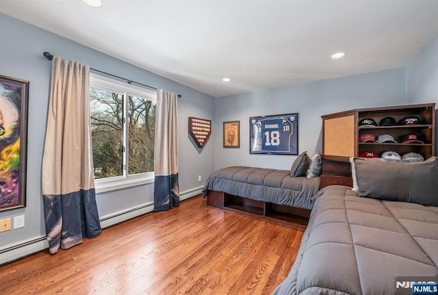 bedroom featuring a baseboard radiator, recessed lighting, and wood finished floors