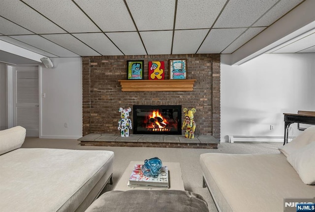 bedroom featuring baseboards, a drop ceiling, a baseboard radiator, and a brick fireplace