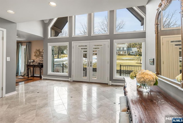 entryway featuring a baseboard radiator, recessed lighting, a baseboard heating unit, a towering ceiling, and french doors