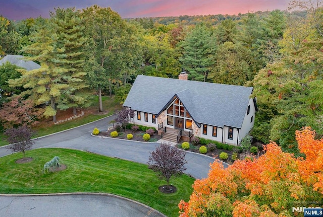 aerial view at dusk with a wooded view