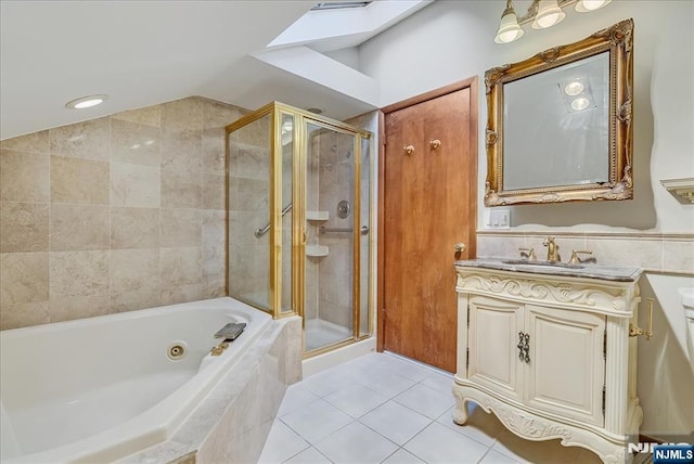 full bathroom featuring vaulted ceiling with skylight, a shower stall, vanity, and tile patterned floors