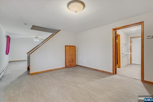 unfurnished living room featuring light wood-style flooring, baseboards, and baseboard heating