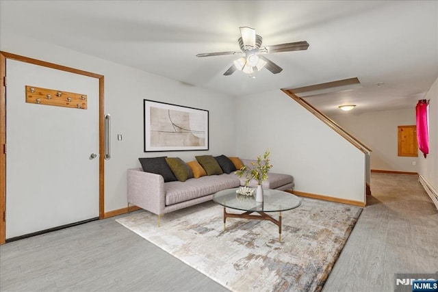 living room featuring baseboards, ceiling fan, and light wood-style floors