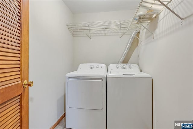 clothes washing area with laundry area, independent washer and dryer, and baseboards