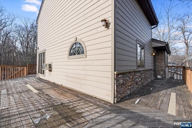 view of property exterior with stone siding and a deck