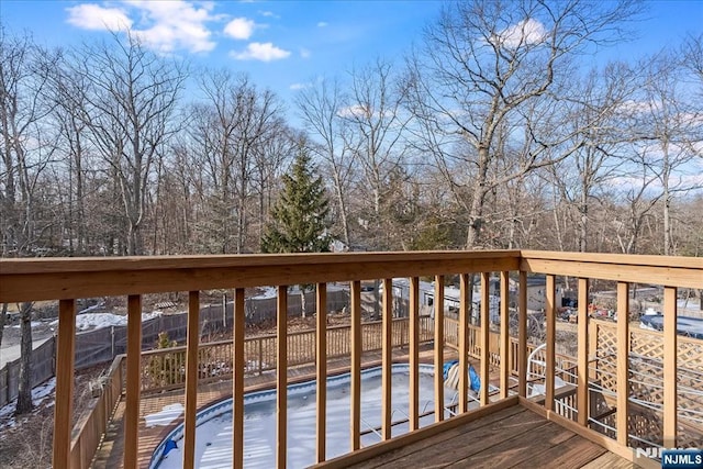 wooden terrace with a fenced in pool and fence