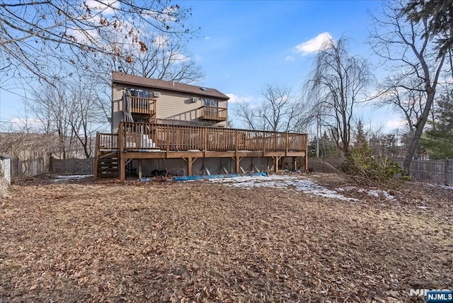 rear view of property with fence, a deck, and stairs