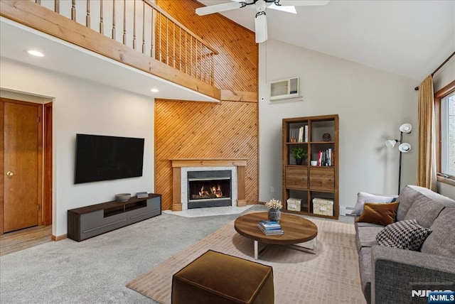 carpeted living area featuring a fireplace with flush hearth, ceiling fan, high vaulted ceiling, and baseboards