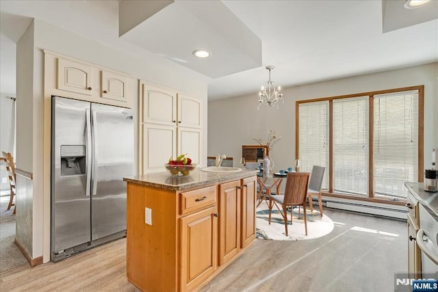 kitchen featuring a center island, pendant lighting, stainless steel refrigerator with ice dispenser, a baseboard radiator, and dark stone counters