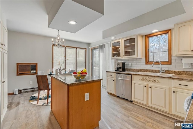 kitchen with a baseboard radiator, stainless steel dishwasher, glass insert cabinets, a sink, and a kitchen island