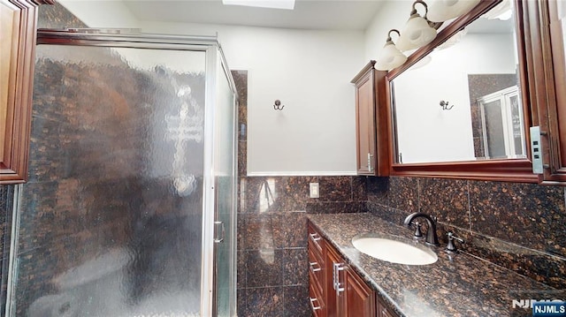 bathroom featuring a shower stall, tile walls, and vanity