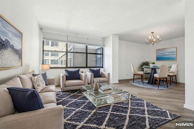 living room with a chandelier, wood finished floors, and baseboards