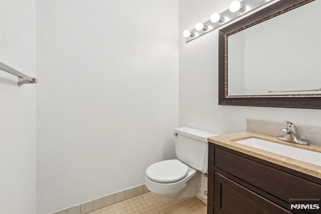 bathroom featuring vanity, toilet, and baseboards