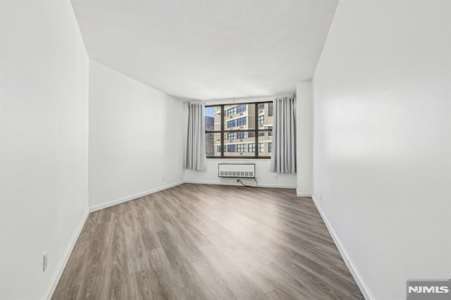 empty room featuring baseboards and wood finished floors