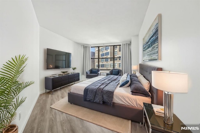 bedroom with baseboards and wood finished floors