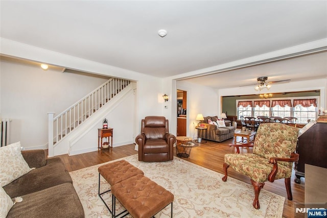 living area featuring stairway, baseboards, and wood finished floors