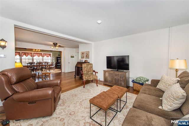 living area with ceiling fan and light wood finished floors