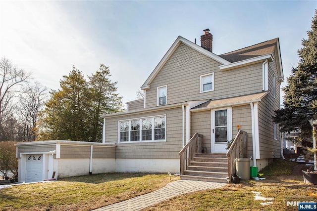 view of front of house with a garage, a front lawn, and a chimney