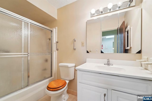 bathroom with shower / bath combination with glass door, vanity, and toilet