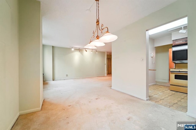 interior space featuring baseboards, light carpet, and track lighting