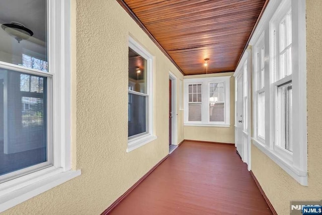 unfurnished sunroom with wood ceiling and a wealth of natural light