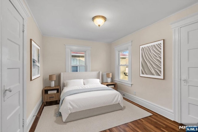 bedroom with dark wood-style floors and baseboards