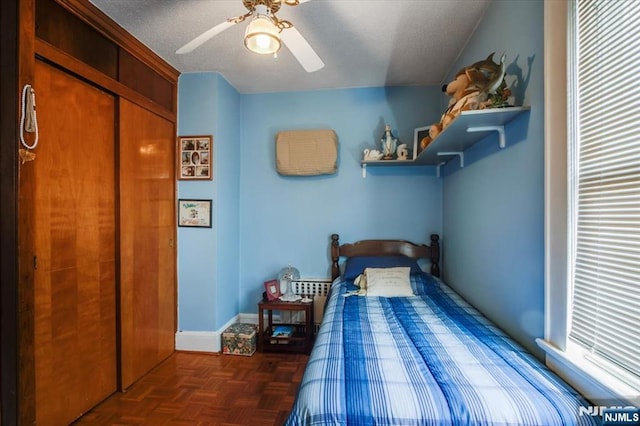 bedroom with a closet, baseboards, and a ceiling fan