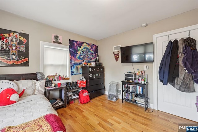 bedroom featuring visible vents and wood finished floors