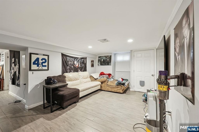 living room with visible vents, crown molding, and wood finished floors