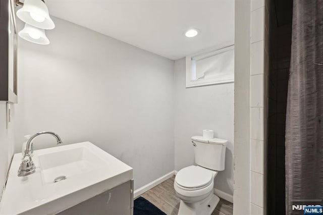 full bathroom featuring baseboards, vanity, toilet, and wood finished floors