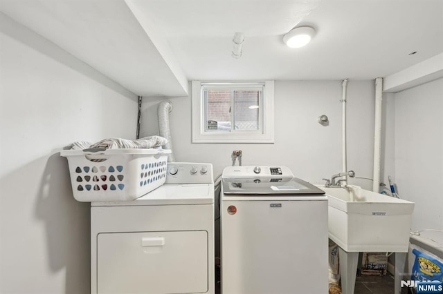 clothes washing area featuring laundry area, separate washer and dryer, and a sink