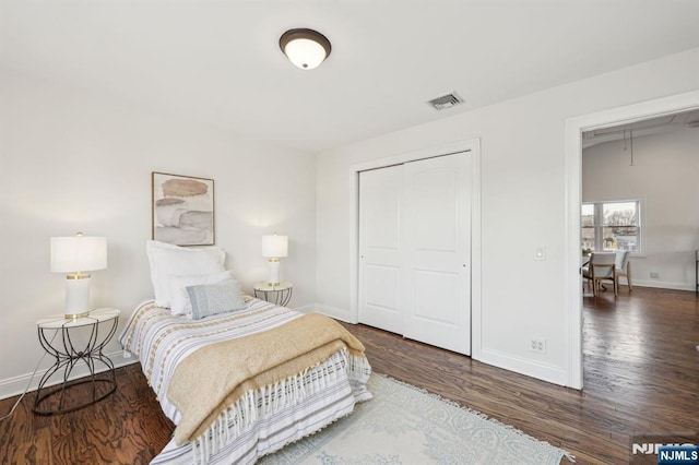 bedroom with attic access, visible vents, baseboards, and wood finished floors