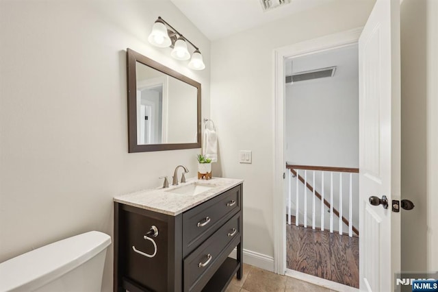 bathroom featuring toilet, visible vents, baseboards, vanity, and tile patterned floors